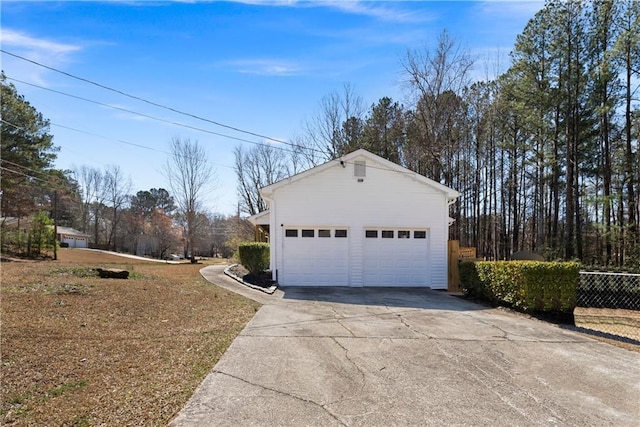 garage with driveway and fence