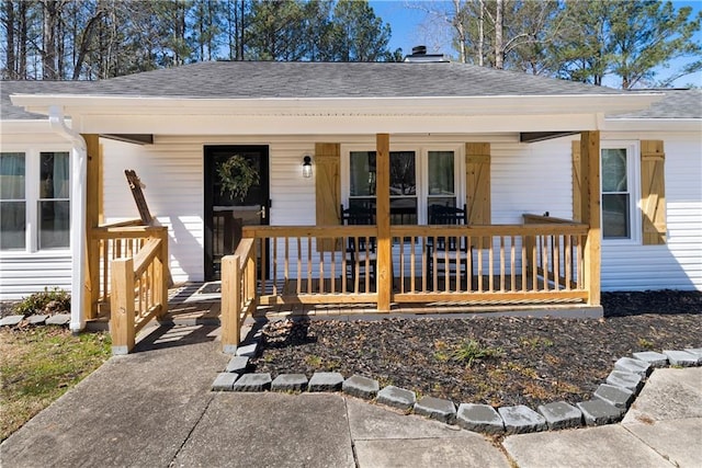 exterior space featuring a porch and a shingled roof