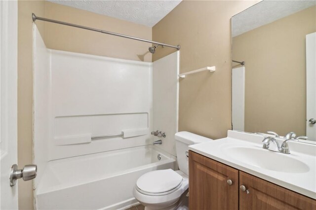 full bathroom featuring  shower combination, vanity, a textured ceiling, and toilet