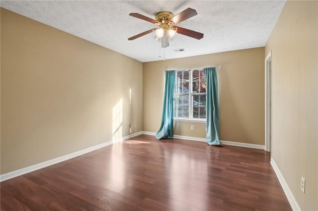 empty room with dark hardwood / wood-style floors, ceiling fan, and a textured ceiling