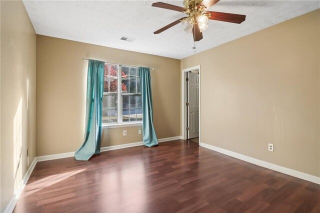 unfurnished room with a textured ceiling, ceiling fan, and dark wood-type flooring