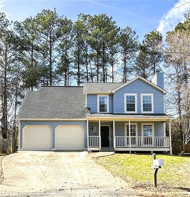 view of front facade with a front lawn, a porch, fence, concrete driveway, and an attached garage