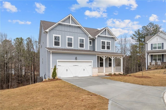 view of front of home featuring a porch, board and batten siding, concrete driveway, and a front lawn