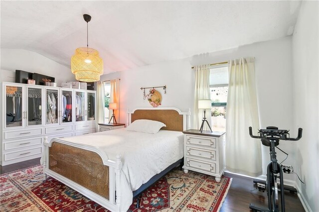 bedroom with dark hardwood / wood-style flooring, vaulted ceiling, and multiple windows