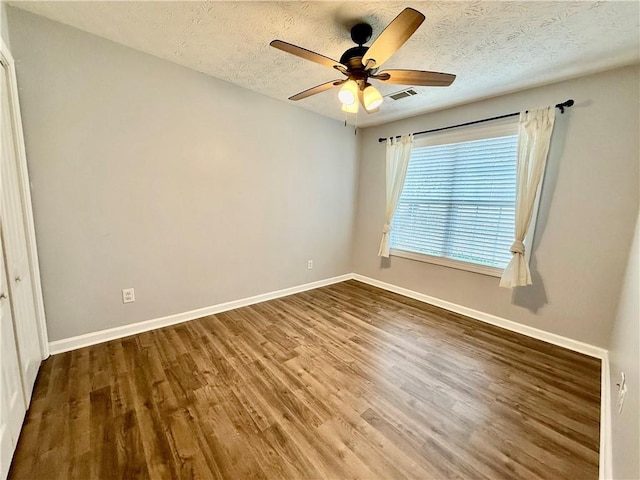 spare room featuring ceiling fan, wood-type flooring, and a textured ceiling