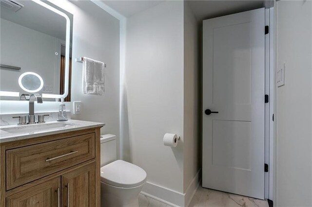 4282 Roswell Rd NE Unit G1, Atlanta, GA 30342 - bathroom featuring toilet, marble look tile flooring, vanity, and baseboards