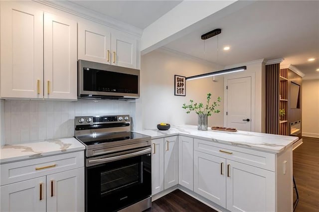 4282 Roswell Rd NE Unit G1, Atlanta, GA 30342 - kitchen featuring appliances with stainless steel finishes, a peninsula, backsplash, white cabinetry, and crown molding