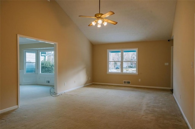 carpeted spare room with ceiling fan, high vaulted ceiling, and a healthy amount of sunlight