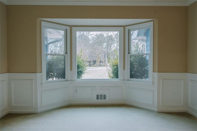 interior space with ornamental molding and light carpet