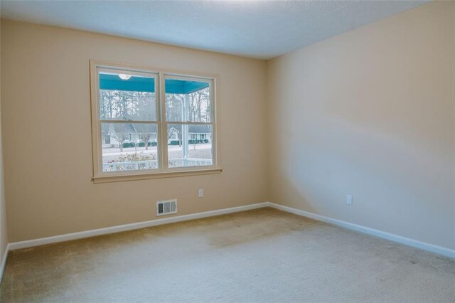 carpeted empty room with a textured ceiling