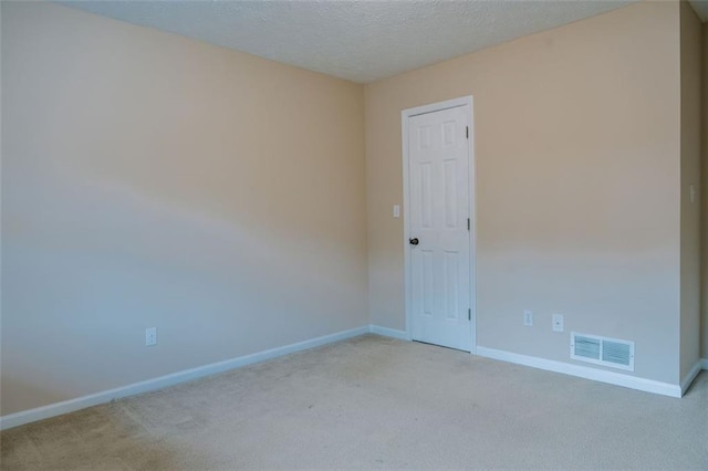 carpeted empty room with a textured ceiling