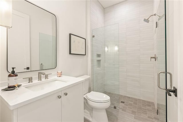 bathroom featuring walk in shower, vanity, and toilet