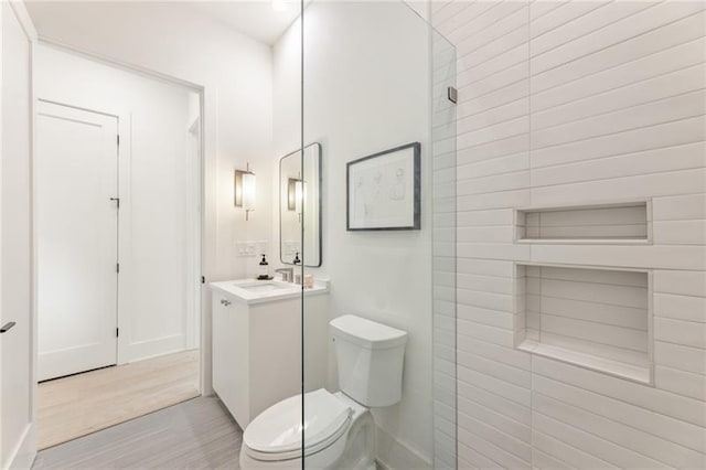 bathroom with toilet, vanity, and hardwood / wood-style flooring