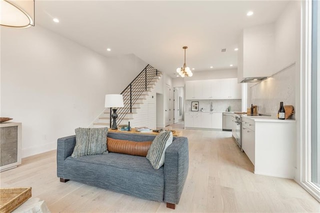 living room with light hardwood / wood-style floors and a chandelier