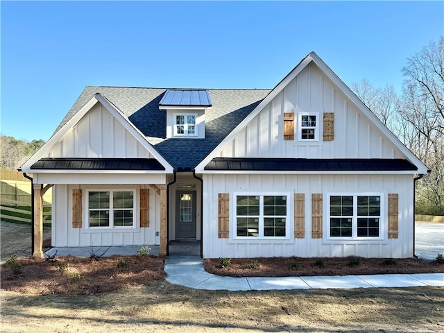 modern farmhouse style home with board and batten siding, a standing seam roof, roof with shingles, and metal roof