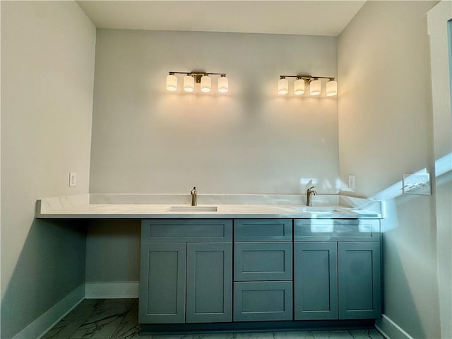 bathroom featuring marble finish floor, a sink, and baseboards