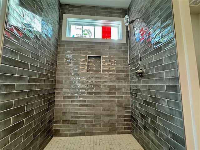 bathroom featuring a tile shower and visible vents