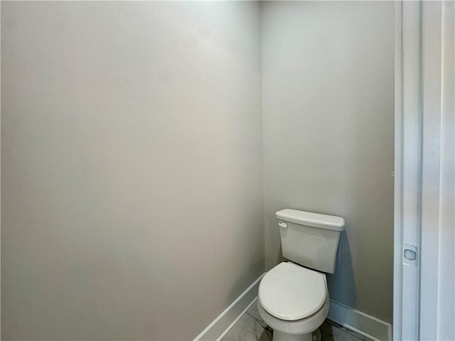 bathroom with toilet and baseboards