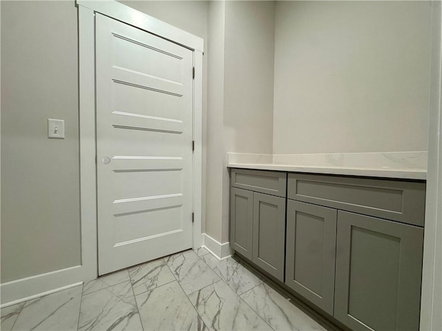 doorway to outside with marble finish floor and baseboards