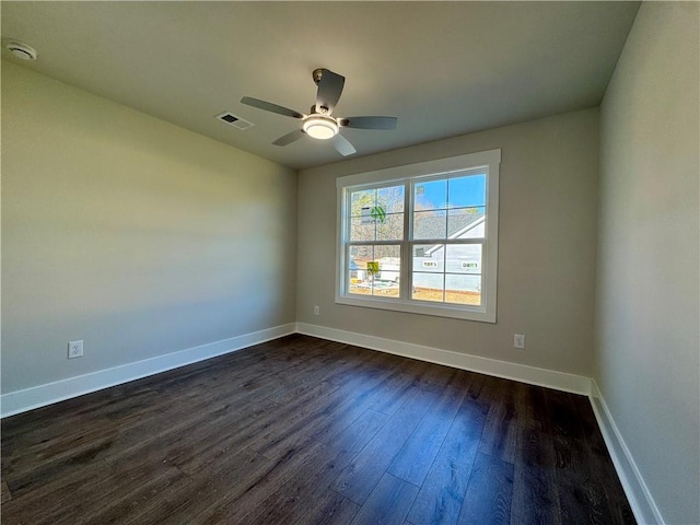 spare room with a ceiling fan, baseboards, visible vents, and dark wood-type flooring