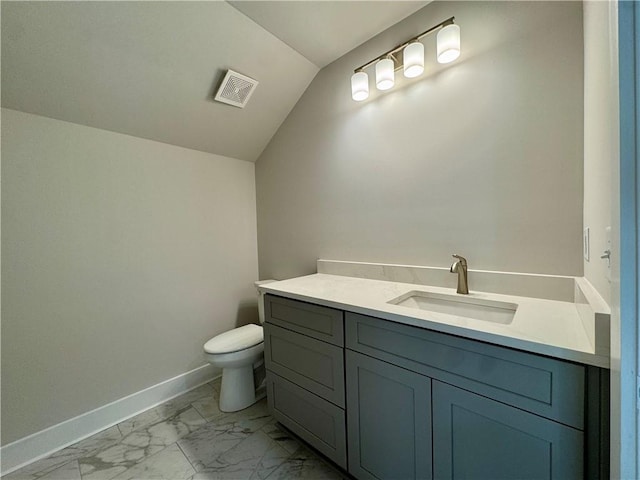 bathroom with baseboards, toilet, marble finish floor, vaulted ceiling, and vanity