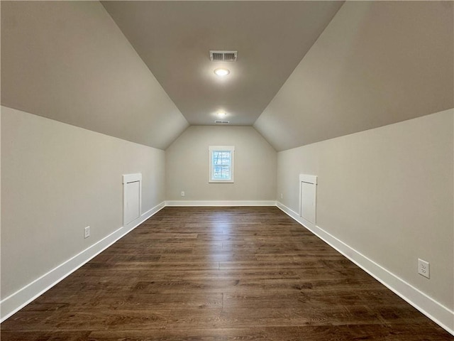 bonus room featuring dark wood-style floors, vaulted ceiling, visible vents, and baseboards