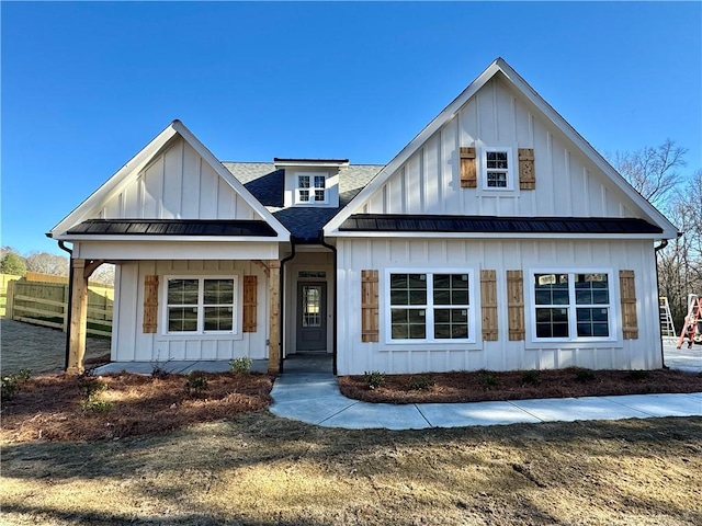 modern farmhouse featuring a standing seam roof, metal roof, board and batten siding, and roof with shingles