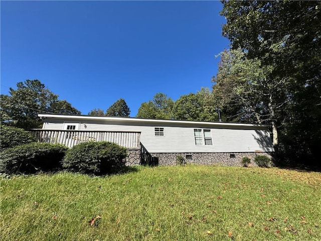 view of side of property featuring a lawn and a wooden deck