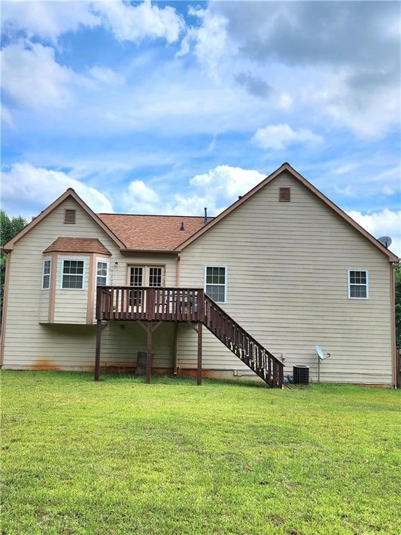 back of house featuring a deck, central AC, and a lawn