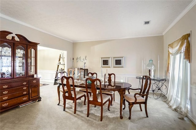 dining room with light carpet and crown molding