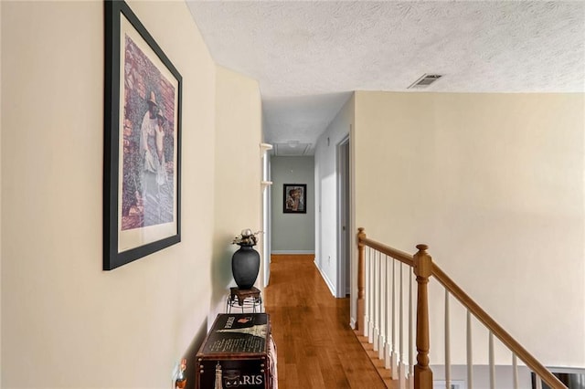 hall with a textured ceiling and hardwood / wood-style flooring