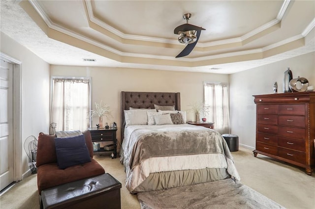 carpeted bedroom with a raised ceiling, ceiling fan, and crown molding