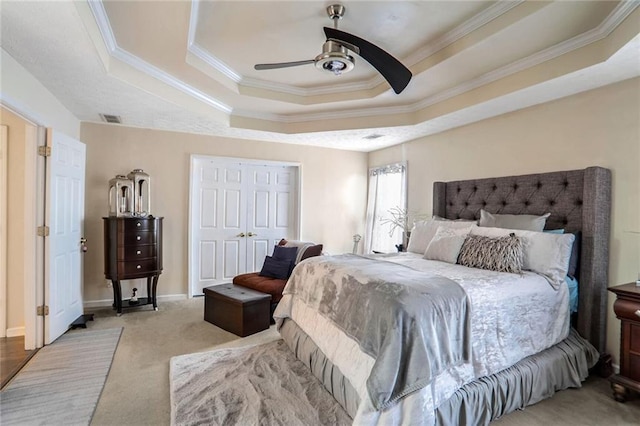 bedroom with ceiling fan, light colored carpet, a closet, and a raised ceiling