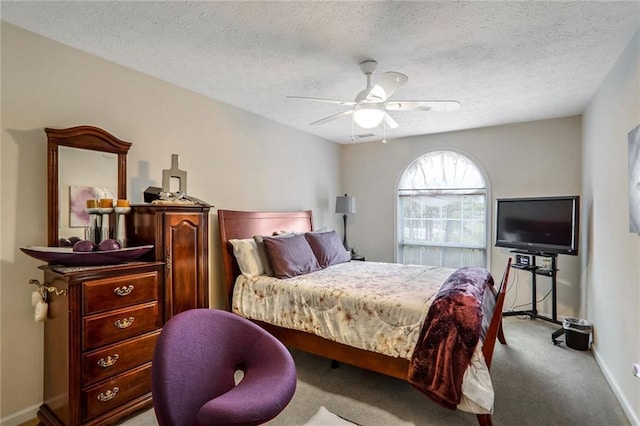 bedroom featuring light carpet, ceiling fan, and a textured ceiling