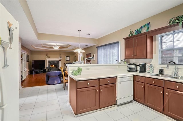 kitchen with a raised ceiling, kitchen peninsula, dishwasher, and sink