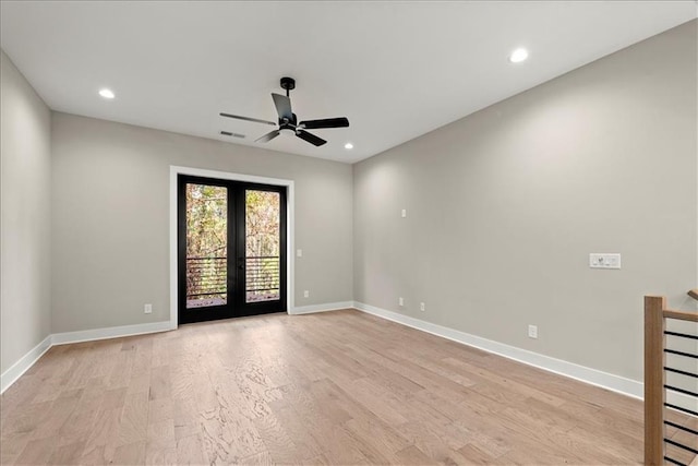 empty room with ceiling fan, light wood-type flooring, and french doors