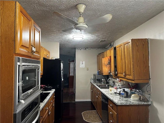 kitchen featuring sink, black appliances, dark hardwood / wood-style floors, ceiling fan, and a textured ceiling