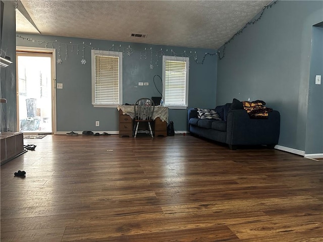 living room with dark wood-type flooring and a textured ceiling