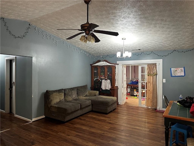 living room featuring lofted ceiling, ceiling fan with notable chandelier, dark hardwood / wood-style flooring, and a textured ceiling