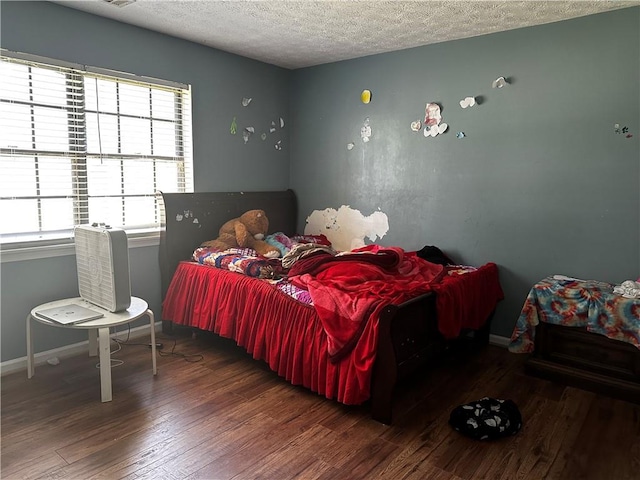 bedroom with dark hardwood / wood-style flooring and a textured ceiling