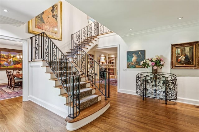 stairs featuring recessed lighting, crown molding, baseboards, and wood finished floors