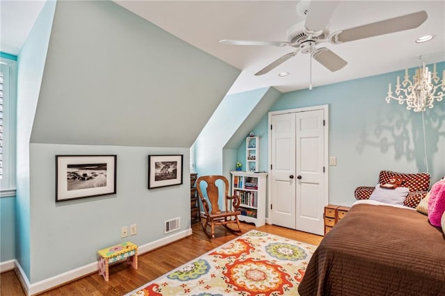 bedroom featuring vaulted ceiling, wood finished floors, visible vents, and baseboards