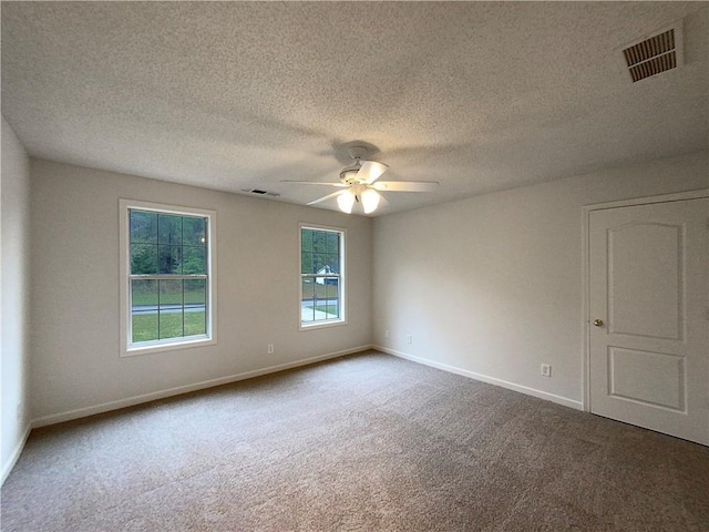 carpeted empty room with ceiling fan and a textured ceiling