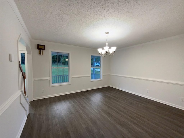 unfurnished room with a textured ceiling, dark hardwood / wood-style floors, ornamental molding, and a notable chandelier