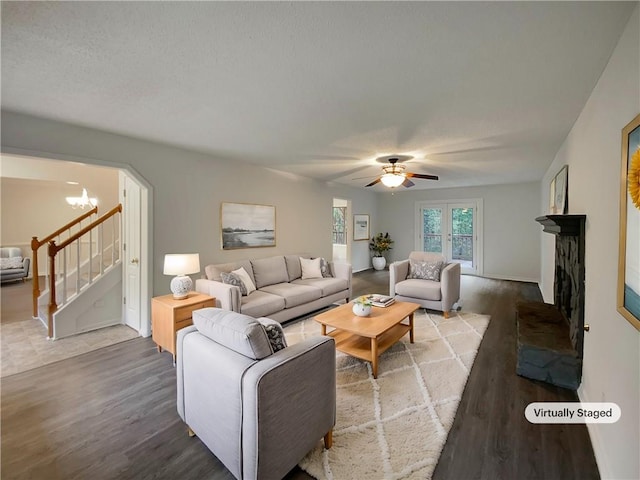 living room with hardwood / wood-style flooring and ceiling fan with notable chandelier