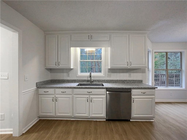 kitchen with dishwasher, white cabinetry, wood-type flooring, and sink