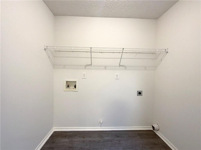 washroom with hookup for an electric dryer, hookup for a washing machine, a textured ceiling, and dark wood-type flooring