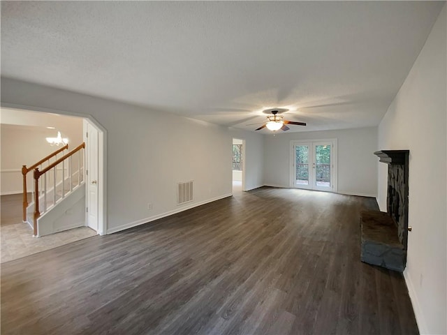 unfurnished living room with dark hardwood / wood-style floors, ceiling fan, a textured ceiling, and french doors