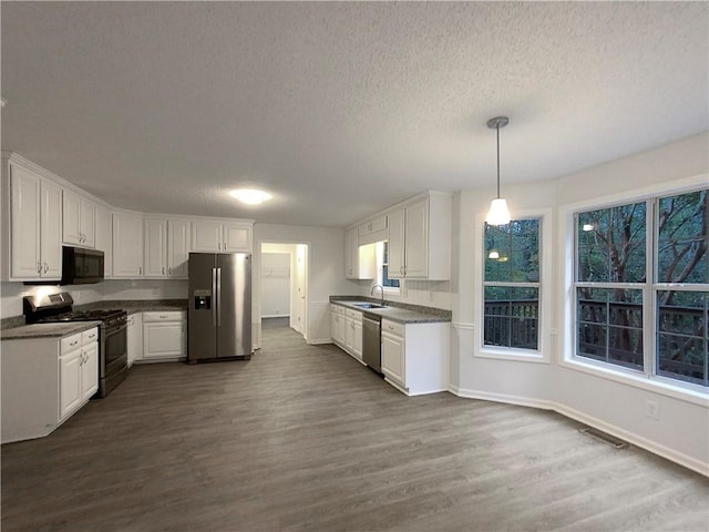 kitchen featuring dark hardwood / wood-style floors, white cabinetry, and stainless steel appliances