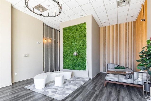 interior space featuring a paneled ceiling and dark hardwood / wood-style floors